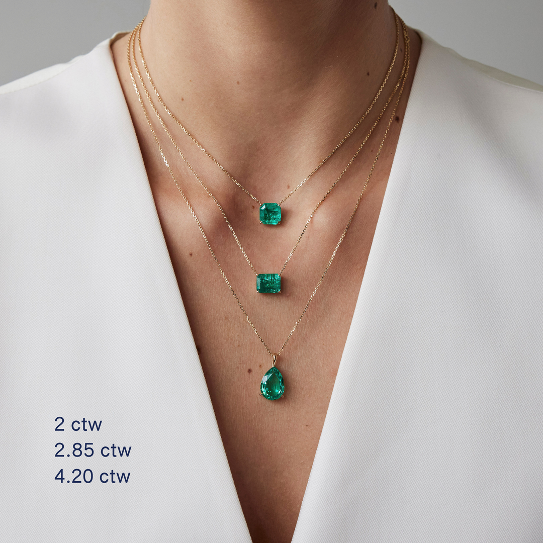 Emerald cut necklace by IRALIS featuring lab-grown emeralds in 14k gold, designed in Zurich on model
