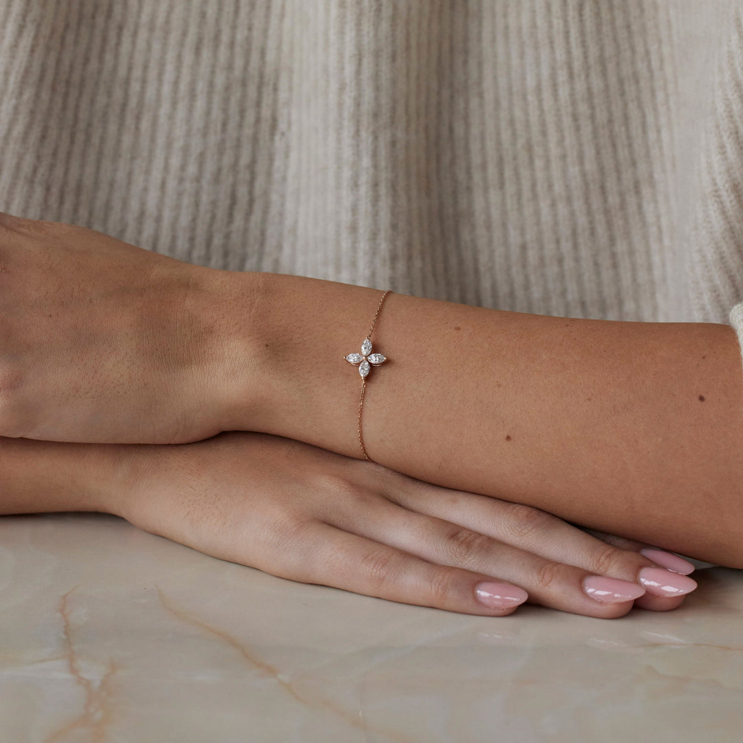 18k rose gold bracelet with a floral lab grown diamond. Four marquise cut diamonds. On model.