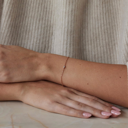 18k rose gold bracelet with small marquise cut lab grown diamond pendant. On model.