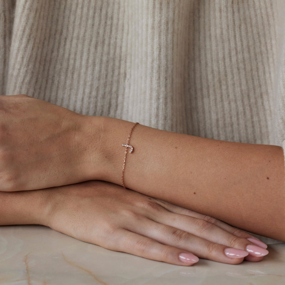 18k rose gold initial bracelet with a lab grown diamond letter 'J' charm. On model.