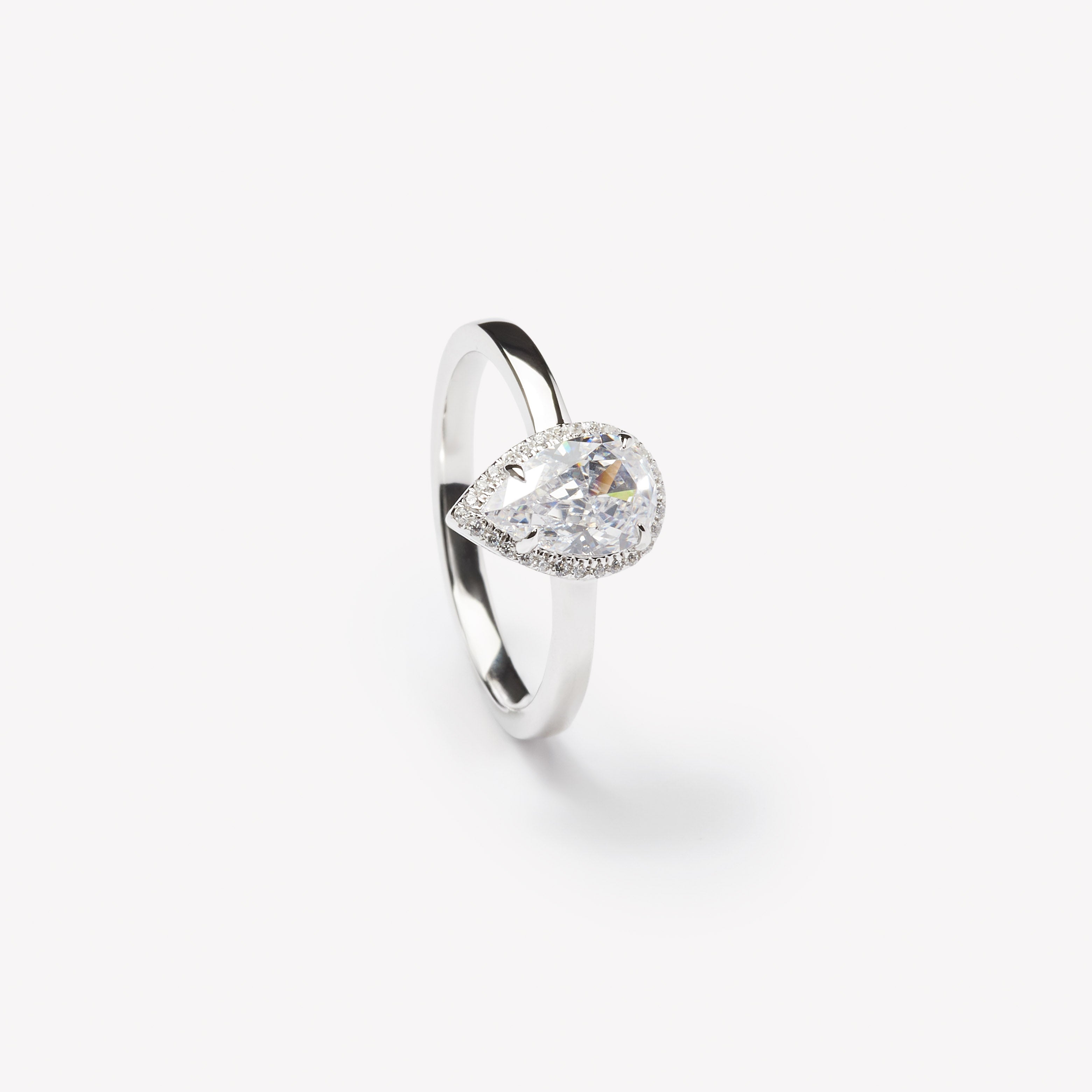 Pear cut engagement ring with halo by IRALIS – Zurich-designed fine jewelry with DEF color and VS1–VS2 clarity.