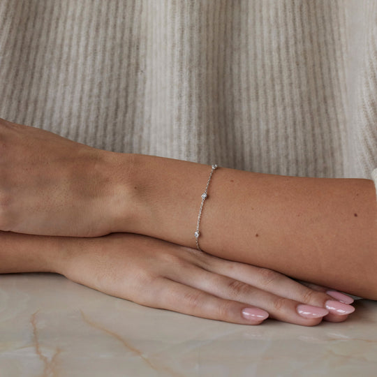 18k white gold bracelet with multiple round brilliant cut diamonds. Adjustable to different lengths. On model.