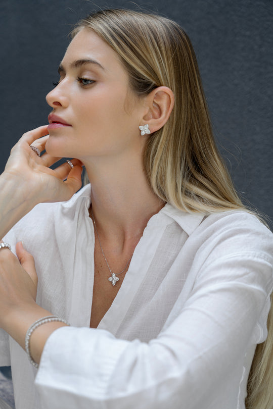 18k white gold lab grown diamond studs. Four marquise cut diamonds embedded in round brilliant cut diamonds. On model.