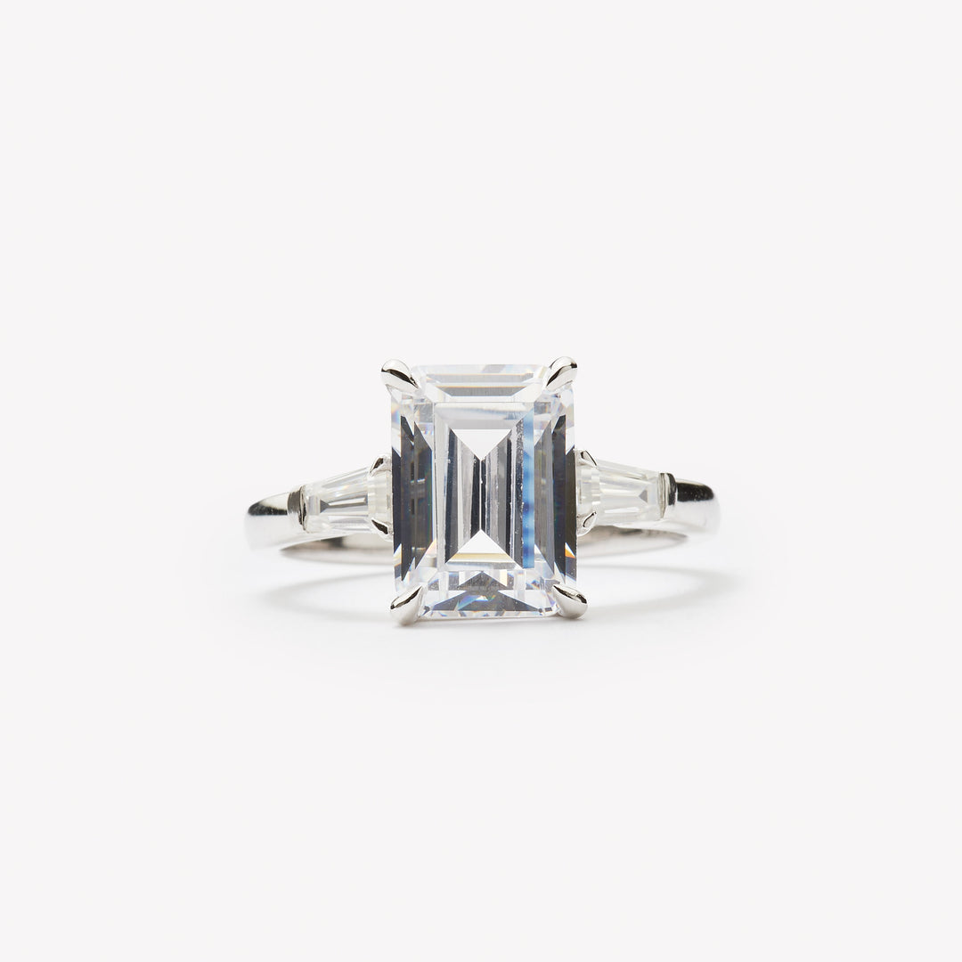 Emerald cut three-stone engagement ring by IRALIS – Zurich-designed fine jewelry with DEF color and VS1–VS2 clarity.