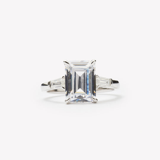 Emerald cut three-stone engagement ring by IRALIS – Zurich-designed fine jewelry with DEF color and VS1–VS2 clarity.