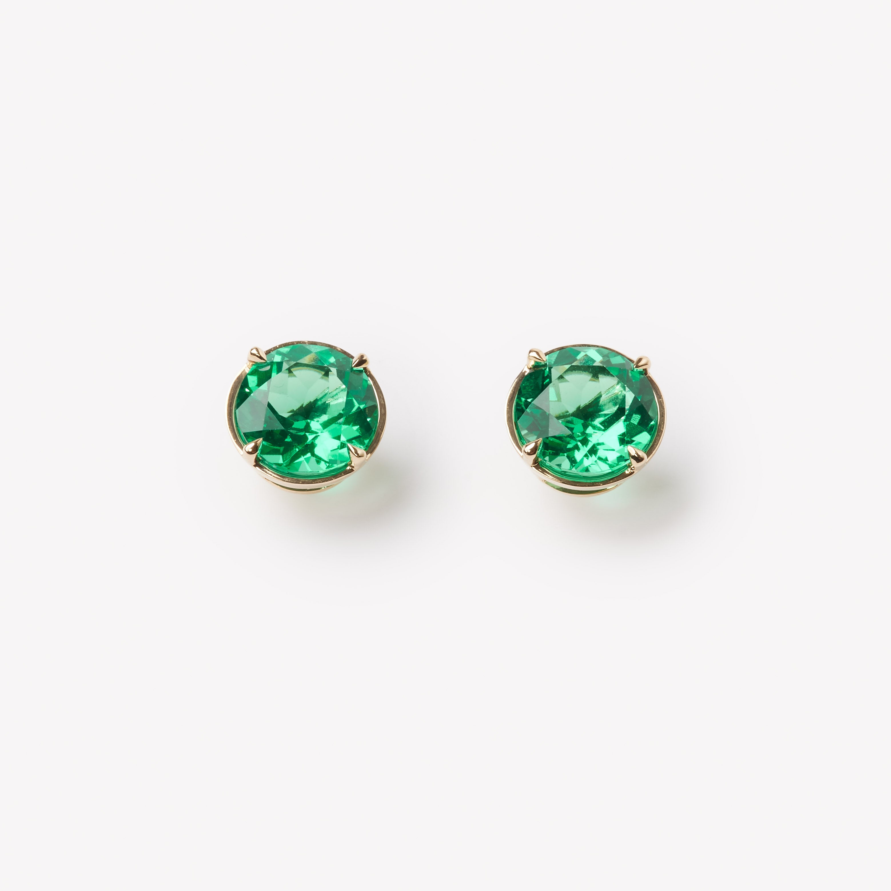18k gold lab grown emerald studs. Round brilliant cut with tiger claw setting. 