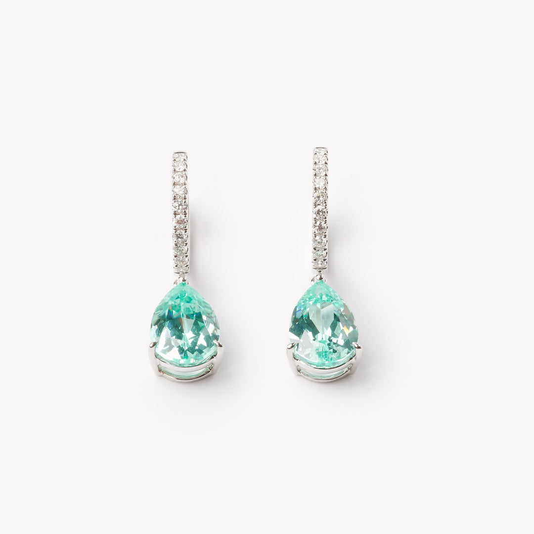 18k gold lab grown paraiba with diamond paved loop. Pear cut in tiger claw setting.